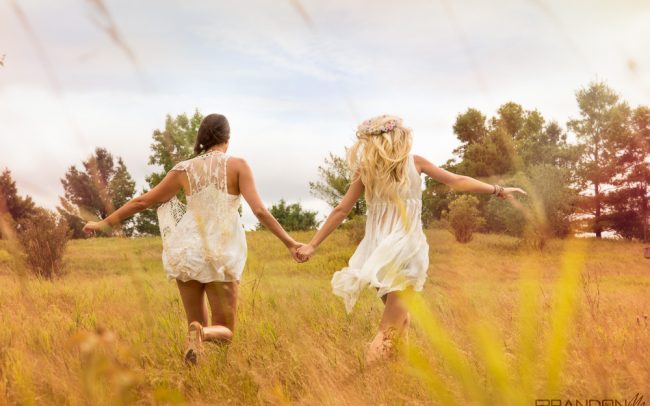 Portrait photography bohemian fashion female models with make-up and styling sunny day playful running through a field