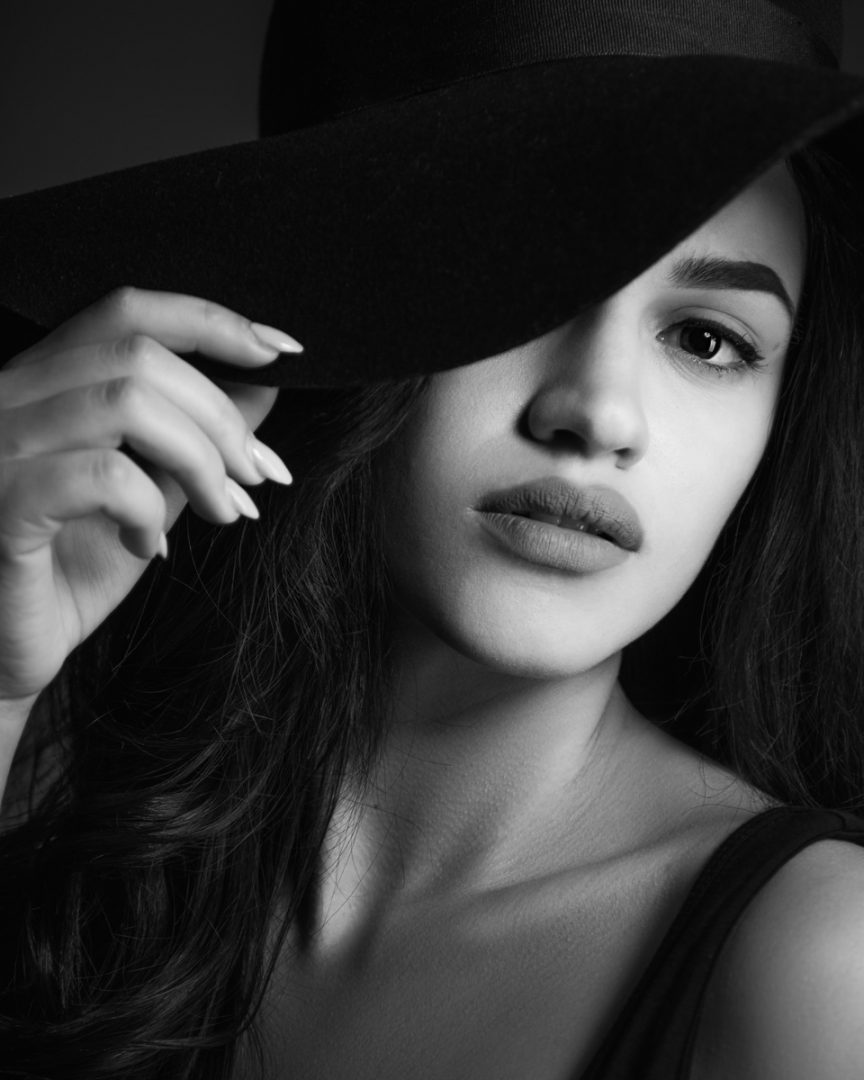 Black & White Photo with Model Heileen Arias and Brandon Marsh Photography Dramatic Moody lighting holding hat fashion portrait