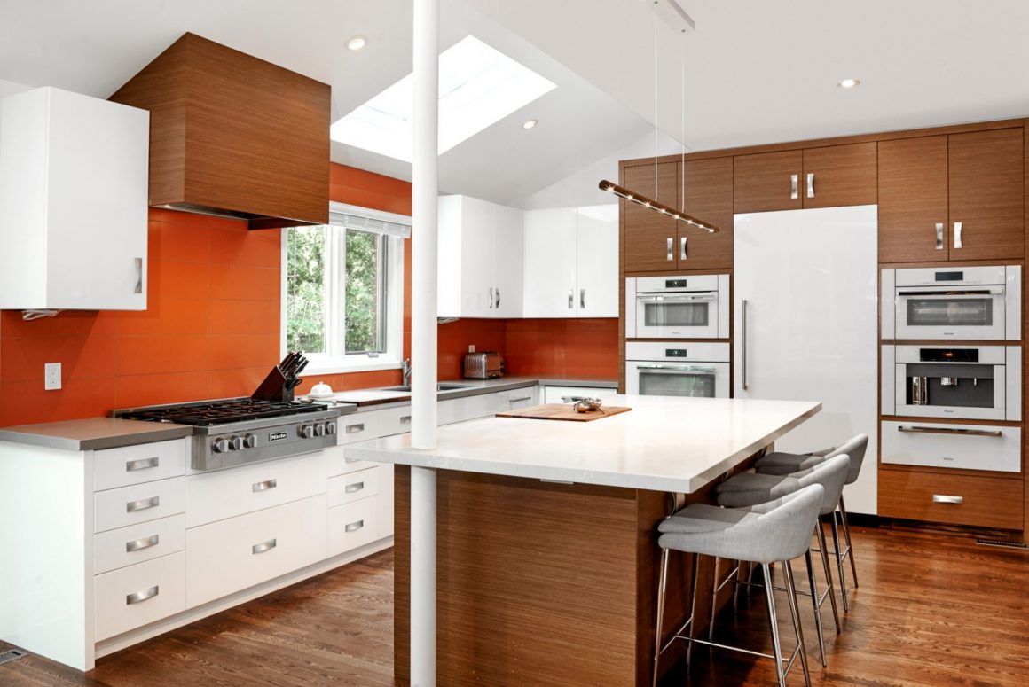 Architectural photo of brown and white cupboard kitchen with orange walls